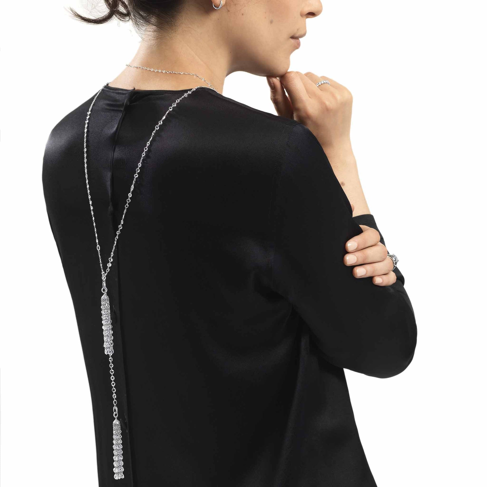 Model wearing ethereal diamond tassel pendant and ethereal rose cut diamond chain necklace.