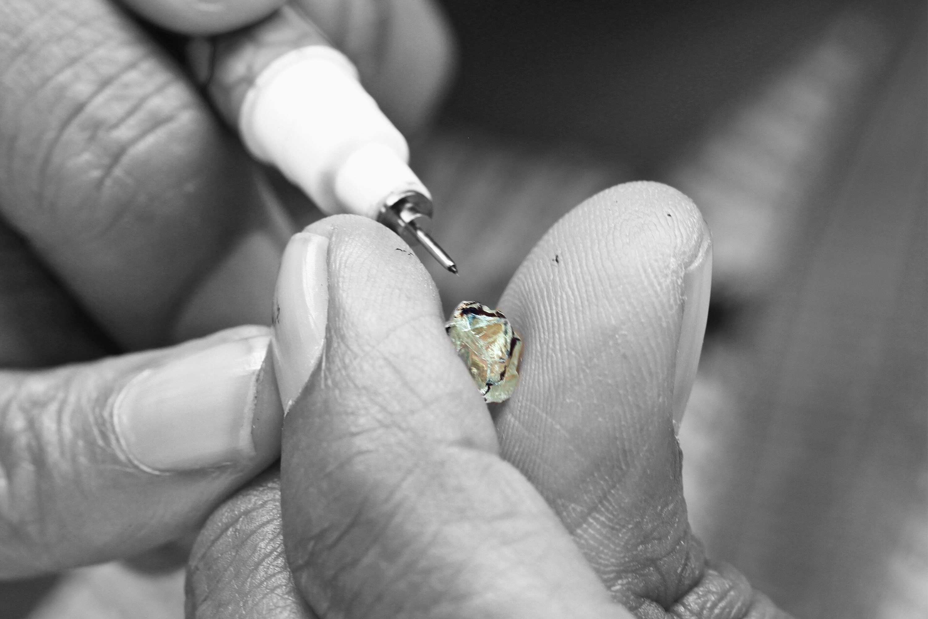 Image of 64Facets craftsman planning how to cut and facet a rough diamond