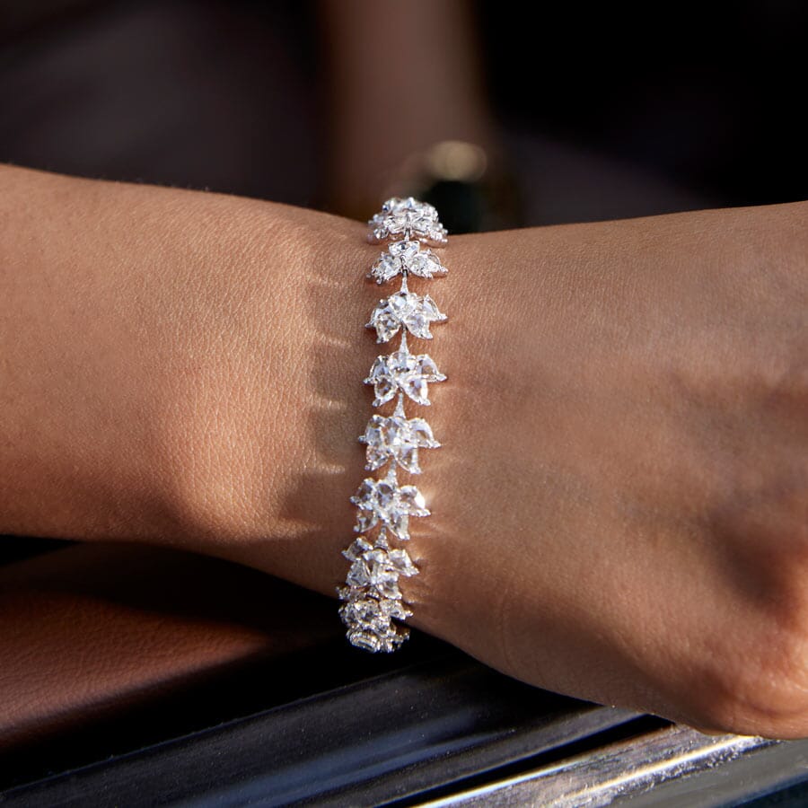 Image of 64facets diamond tennis bracelet made with lotus shaped diamonds wrapping around the wrist and set in 18k gold