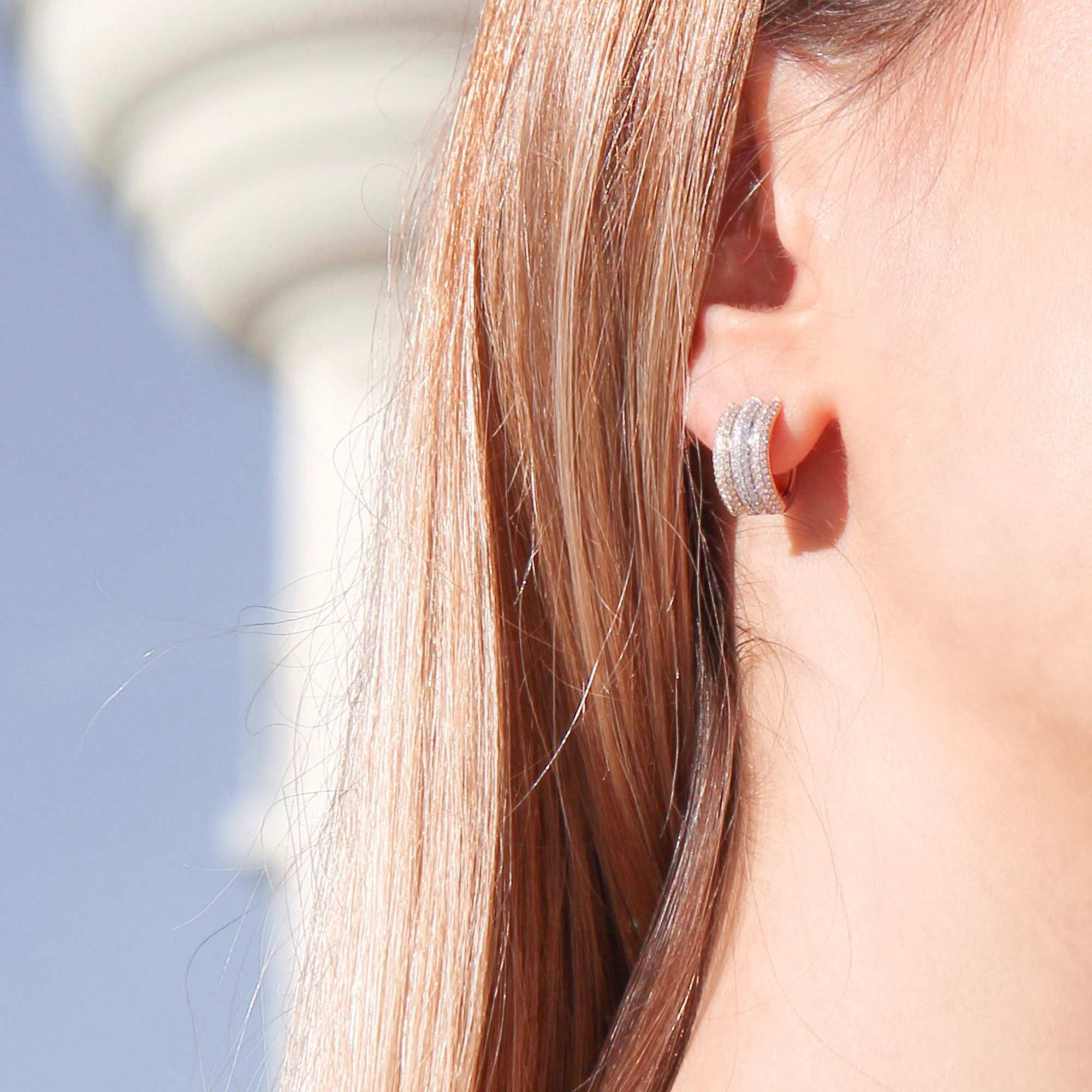 Image of 64facets diamond huggie earrings with three gold tones and diamonds in a pave setting